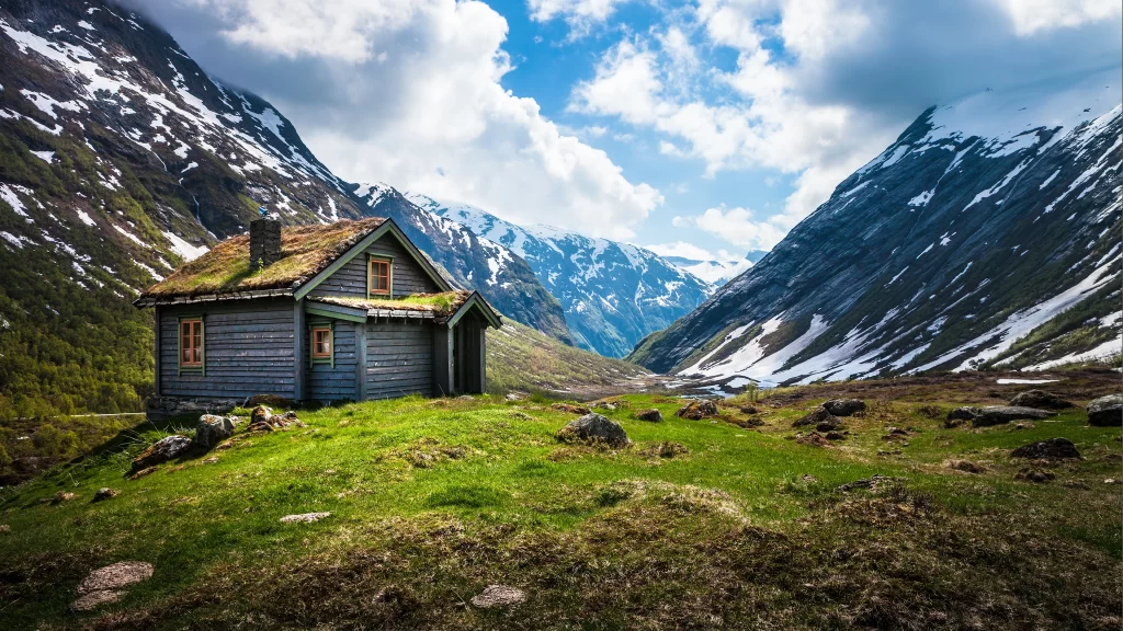 mountains cabin grass snow sky clouds