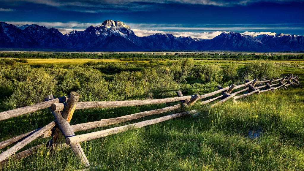 mountains grass fence sky clouds landscape