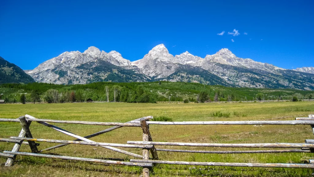 mountains grassland fence clear sky greenery natural landscape