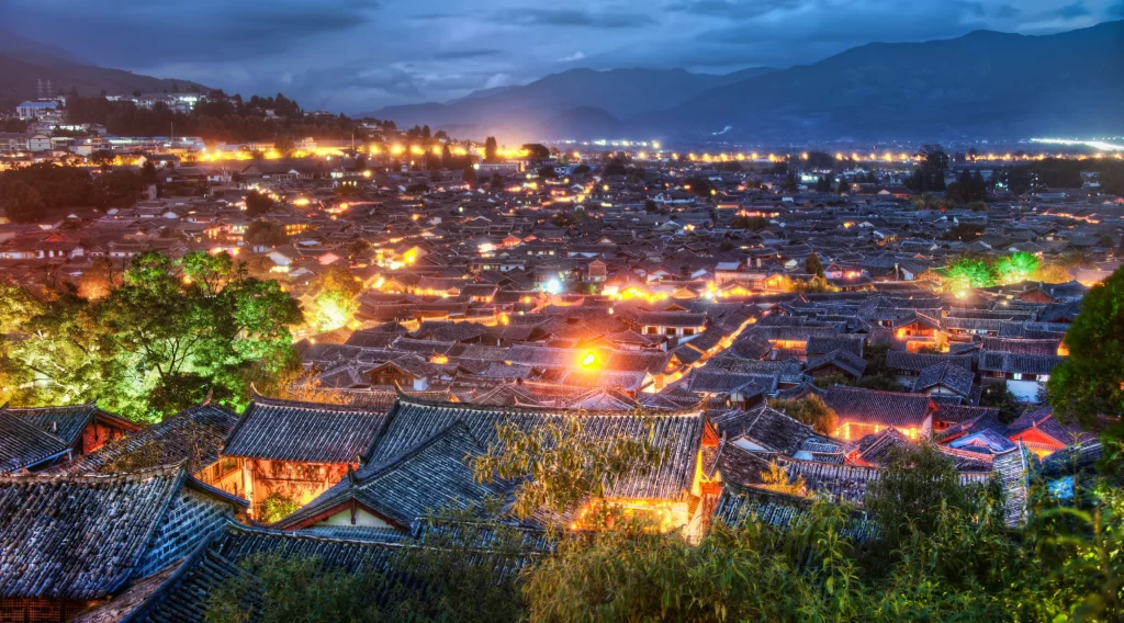 night city lights buildings mountains sky