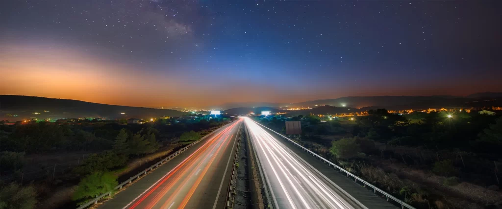 night sky stars highway lights landscape
