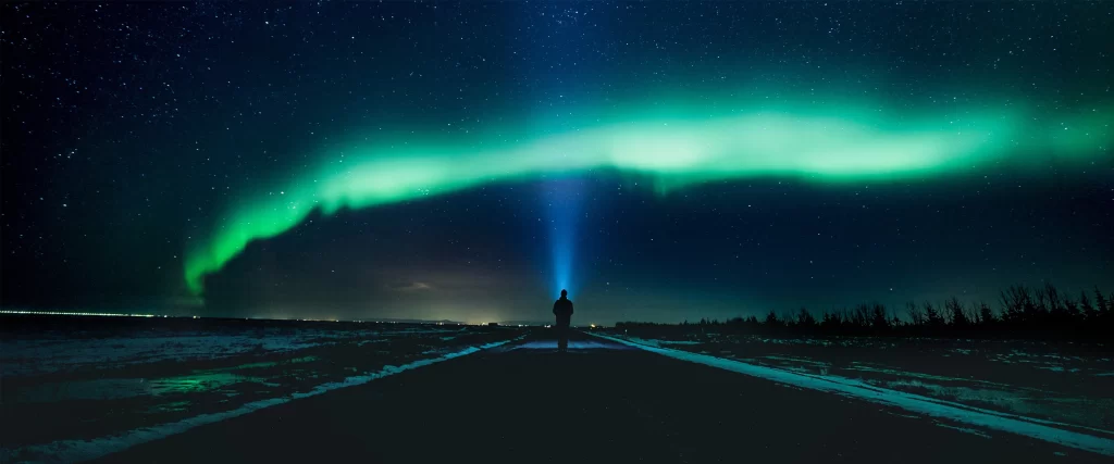 Northern lights night sky stars road person forest