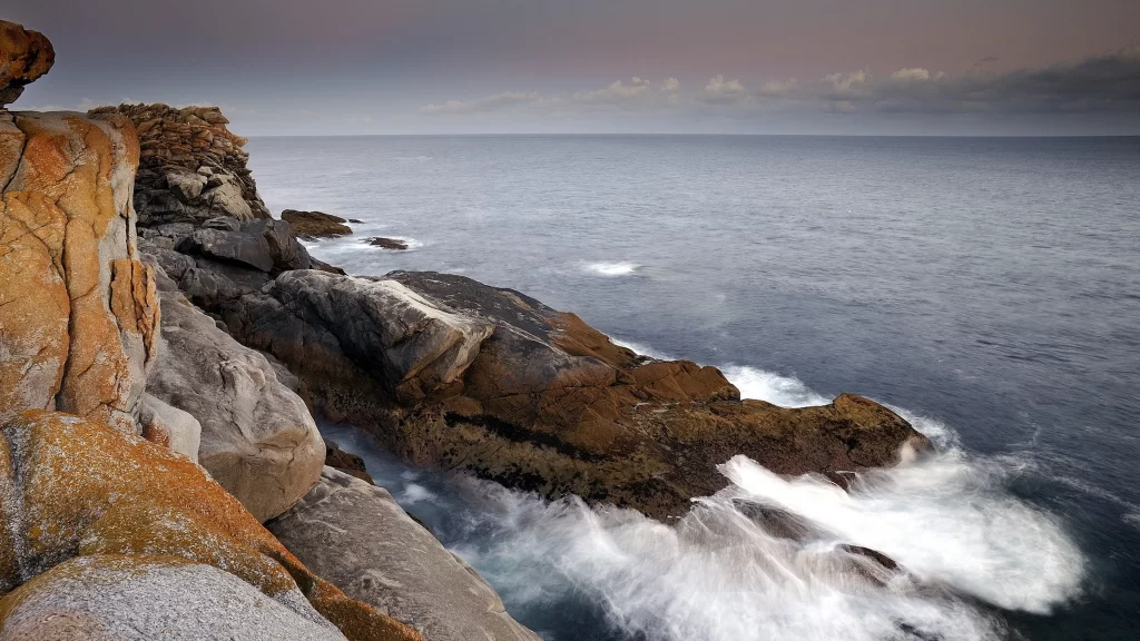 ocean waves rocky shore cloudy sky
