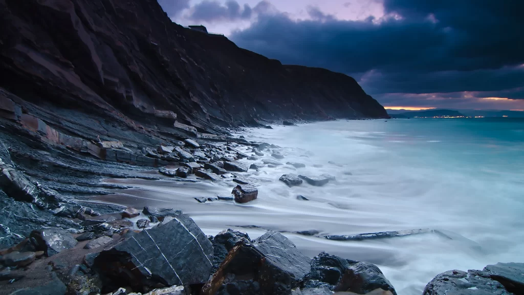 ocean waves rocky shore stormy sky dramatic landscape