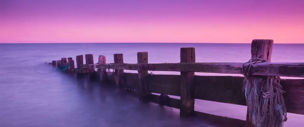 purple sky wooden pier calm water twilight serene