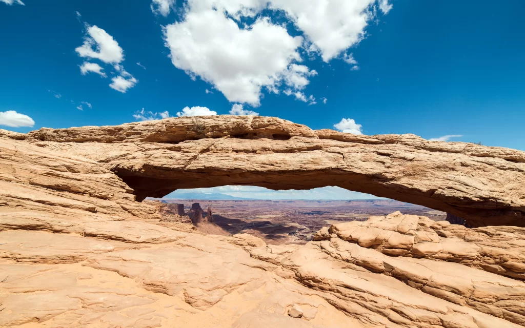 rock arch landscape canyon sky clouds