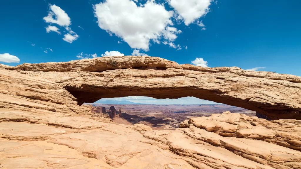 rock arch landscape canyon sky clouds
