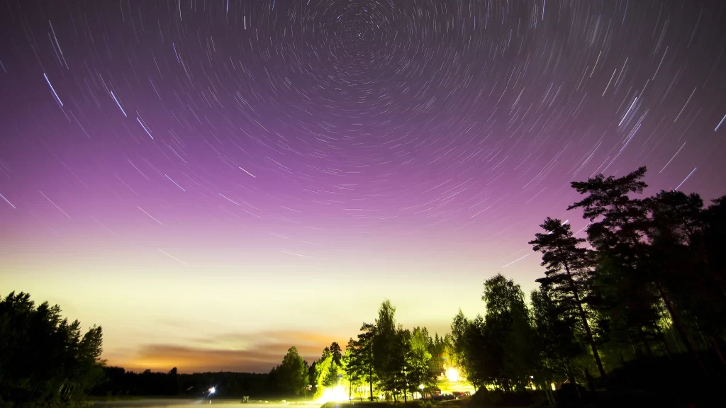 starry sky long exposure trees night purple horizon lights serene