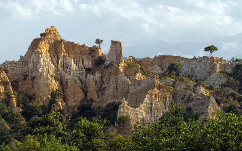 Rocky Cliffs Greenery Trees Mountain Peaks Cloudy Sky