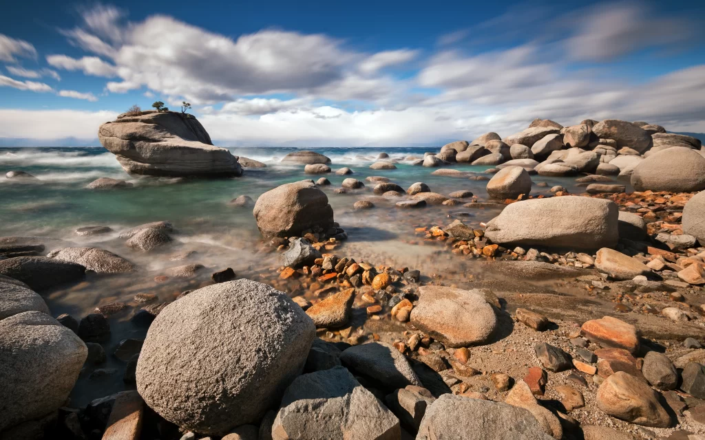 Rocky Shoreline Clear Water Blue Sky Clouds