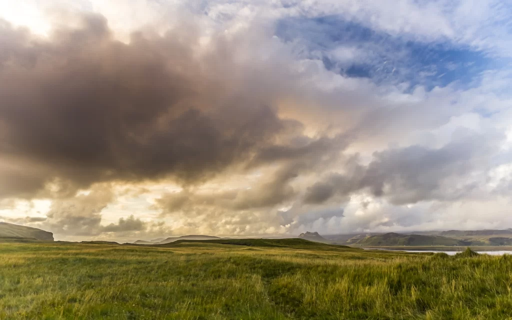 Lush Green Field Rolling Hills Cloudy Sky Sunlight