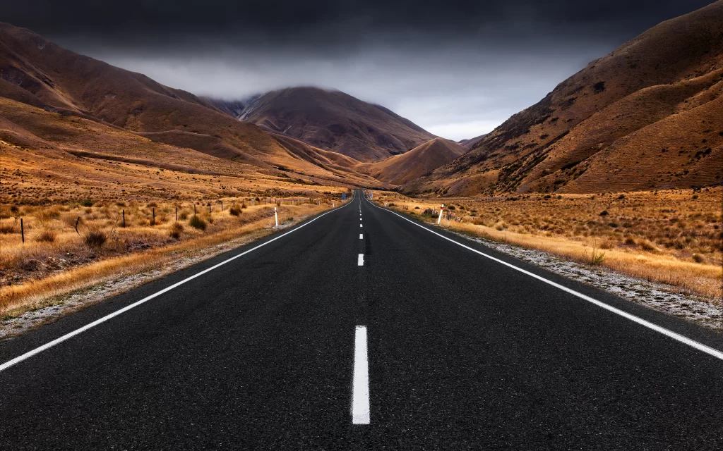 Desolate Road Rolling Hills Golden Grasslands Cloudy Sky