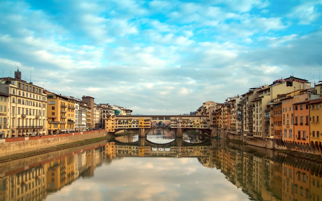 Historic Bridge River Reflections Colorful Buildings Cloudy Sky