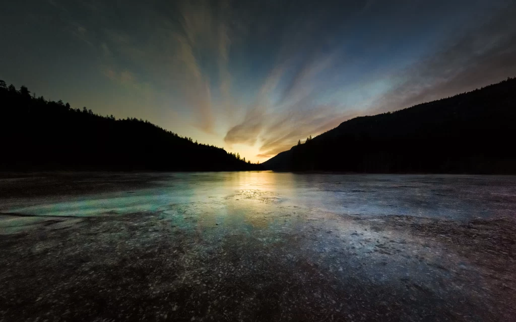 Frozen Lake Sunset Silhouetted Trees Mountain Horizon