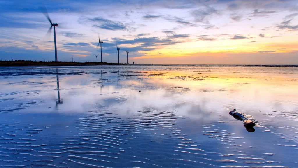 wind turbines sunset reflection water clouds
