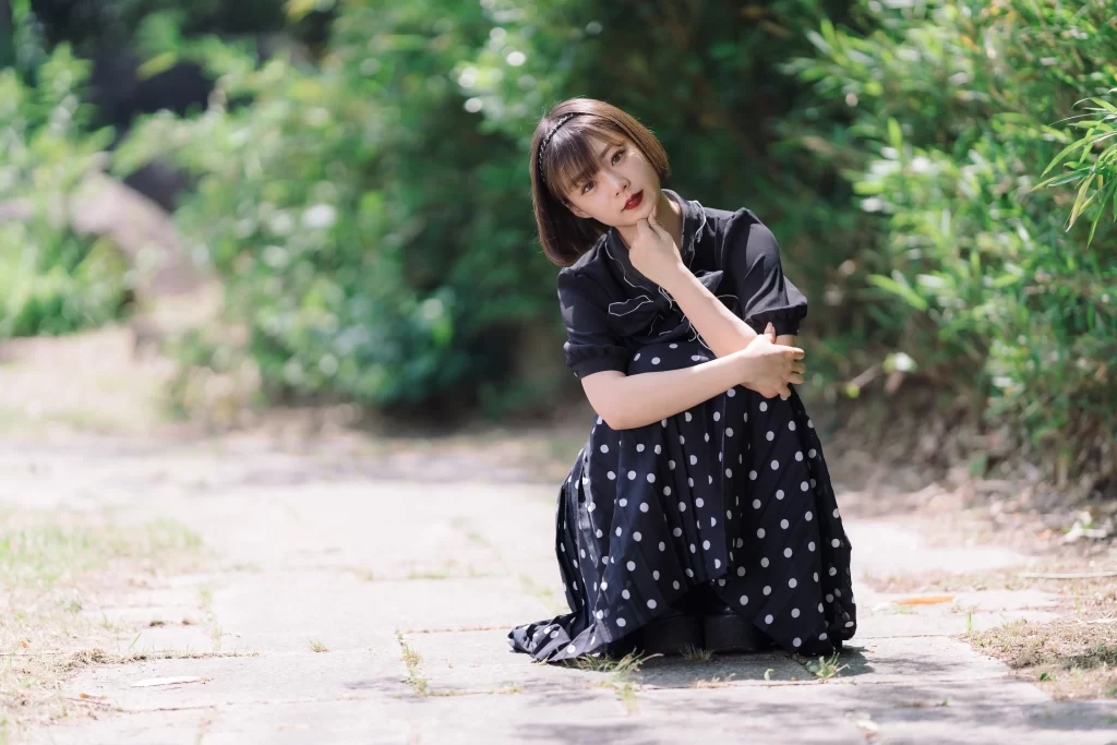 woman dress polka dot sitting outdoor greenery