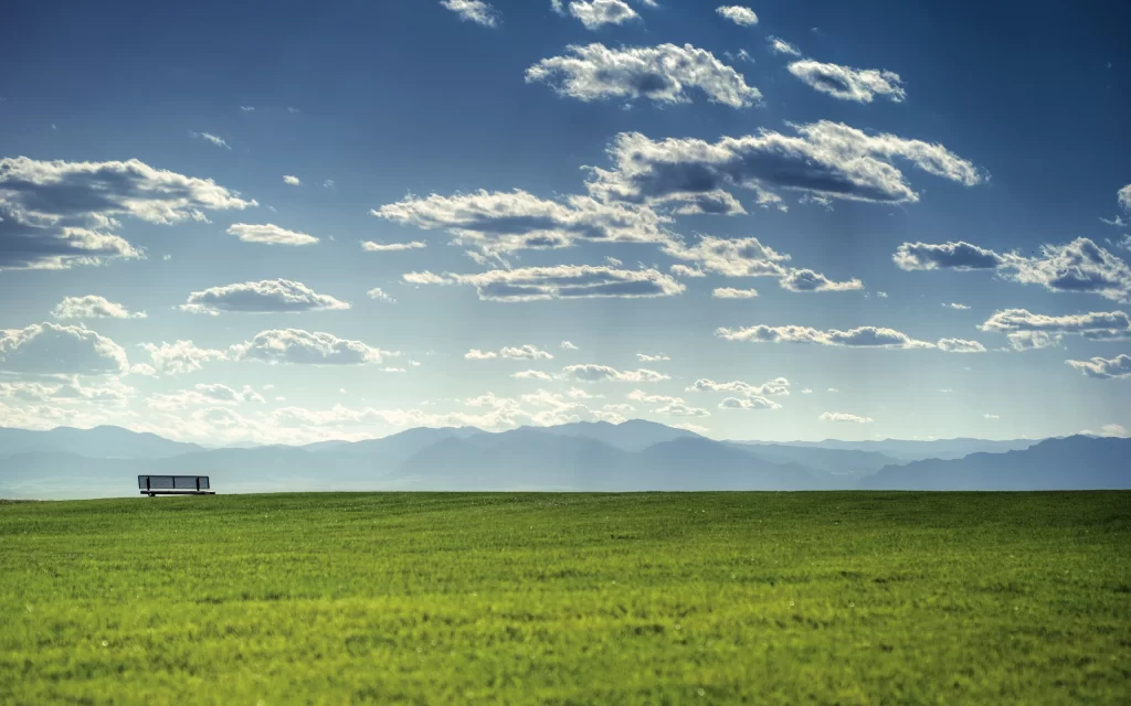 Lush Green Field Blue Sky White Clouds Mountain Range Scenic