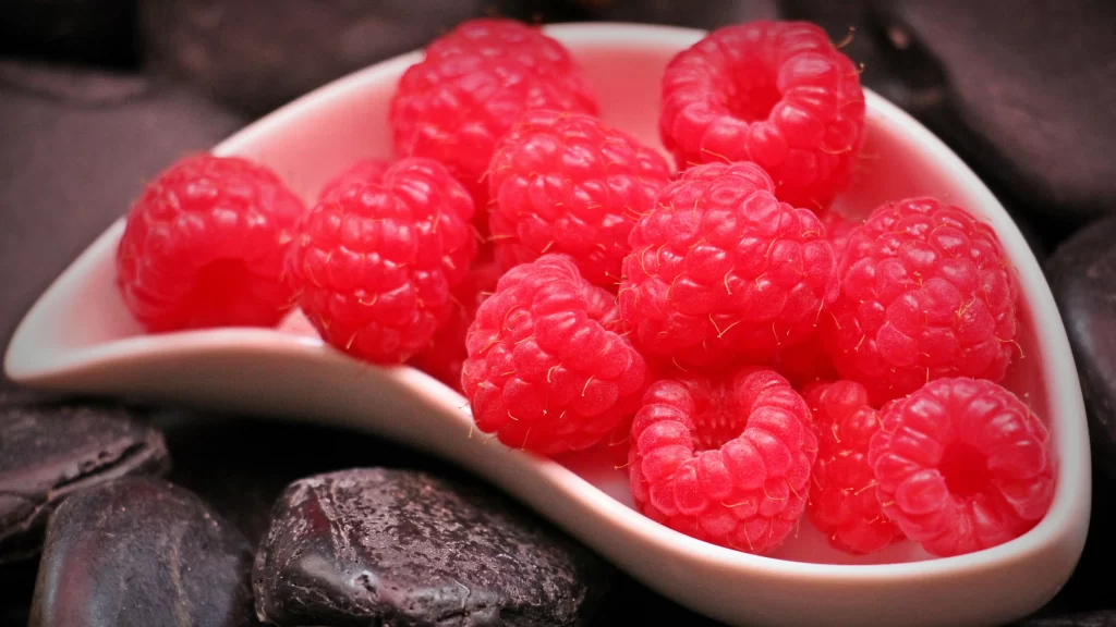Raspberries White Dish Chocolate Rocks Dark Background