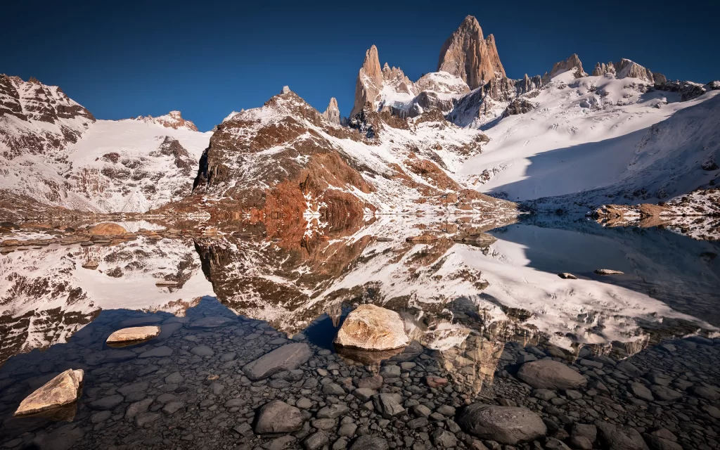 Snowy Peaks Clear Lake Reflections Rocky Terrain Blue Sky