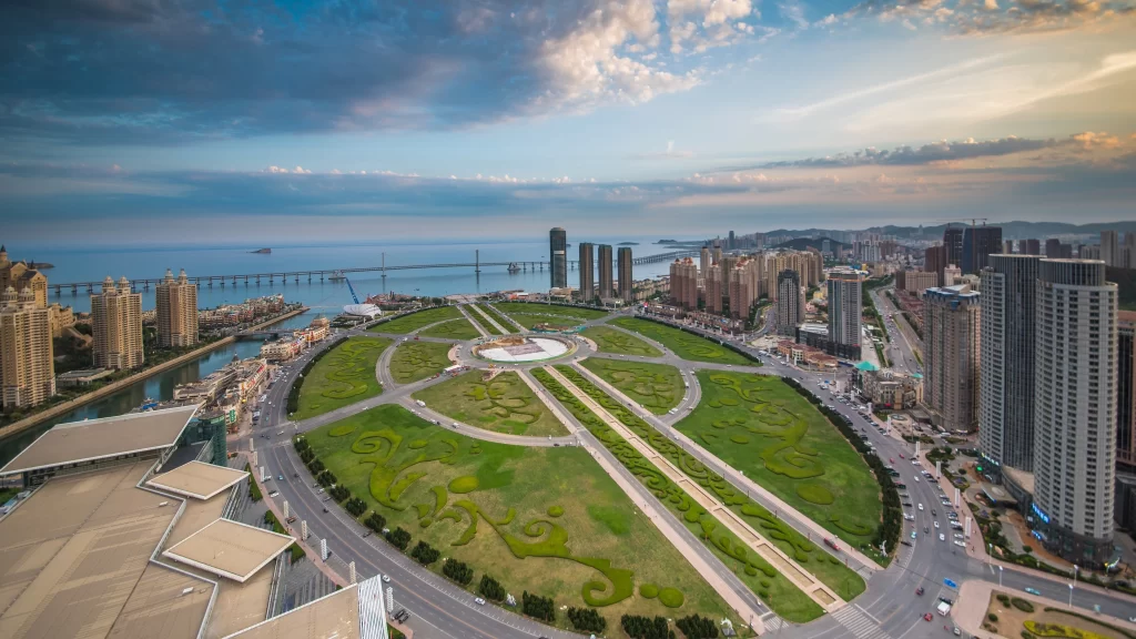 Urban landscape green park skyscrapers coastal city bridge blue sky