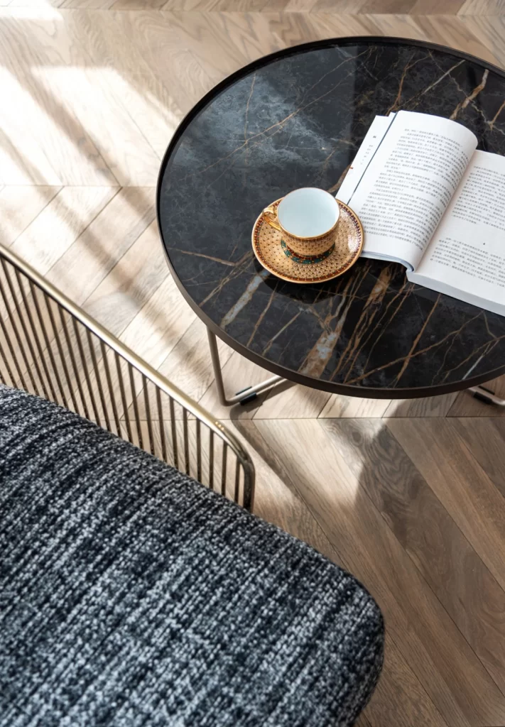 Cozy Reading Nook Dark Marble Table Gold Accents Textured Fabric Neutral Tones