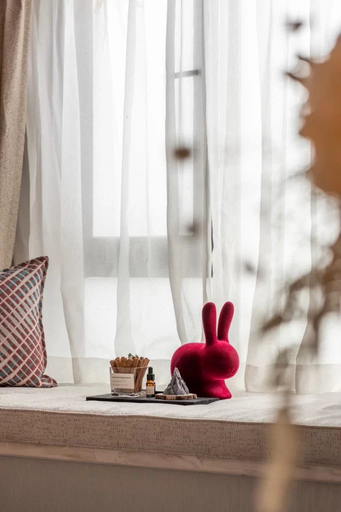 Cozy Window Seat Soft Textures Neutral Tones Red Accent Decorative