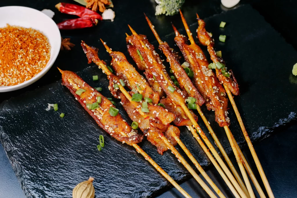 Crispy Pork Skewers Sesame Garnish Charred Edges