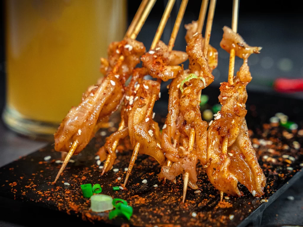 Crispy Pork Skewers Spicy Sauce Sesame Garnish