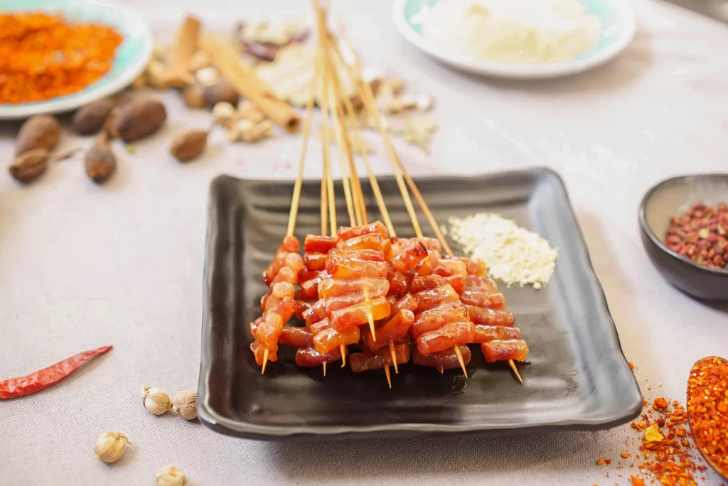 Glistening Pork Skewers Spicy Sauce Golden Brown Plate