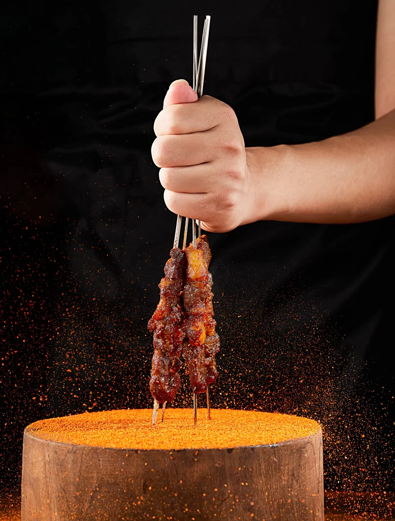 Golden Brown Beef Skewers with Reddish Spices on Wooden Plank
