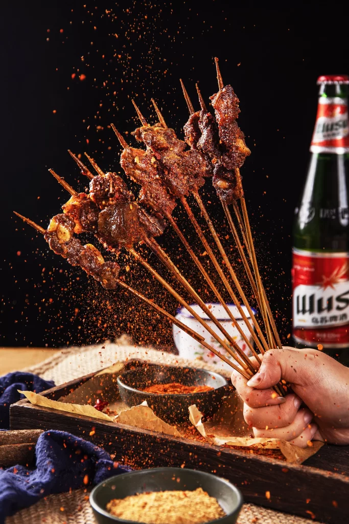 Golden Brown Beef Skewers with Spices on Dark Plate