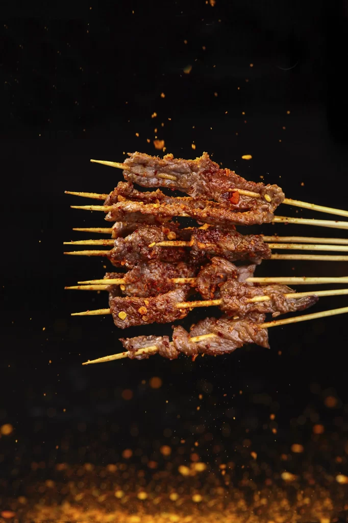 Golden Brown Beef Skewers with Spices Sizzling on Grill