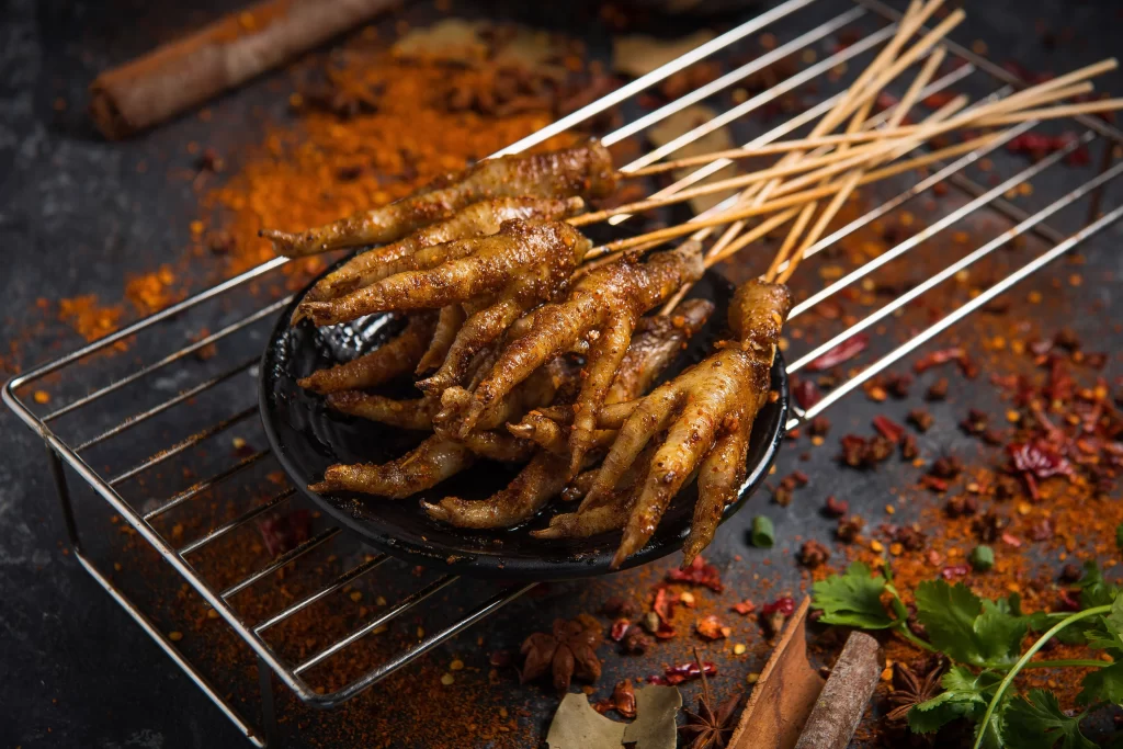Golden Brown Chicken Feet on Black Plate with Spices