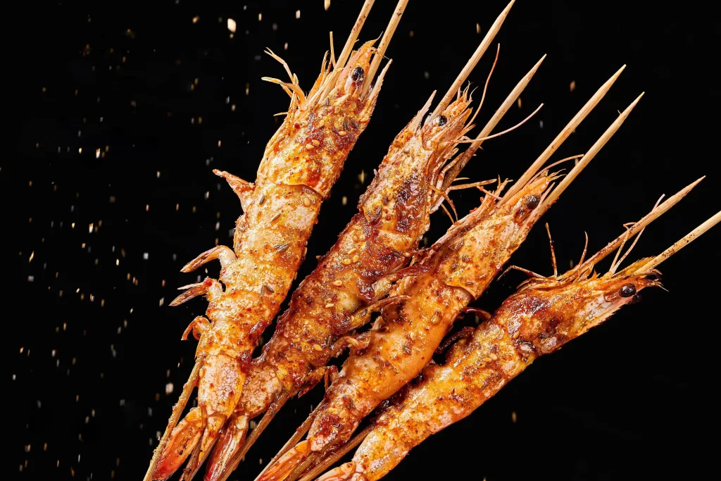 Golden Brown Grilled Prawns with Spices on Black Plate