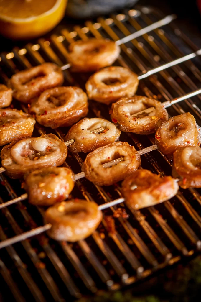 Golden Brown Pork Belly Slices on Silver Grill with Reddish Char