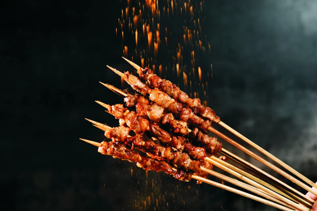 Golden Brown Pork Skewers with Charred Edges and Reddish Seasoning