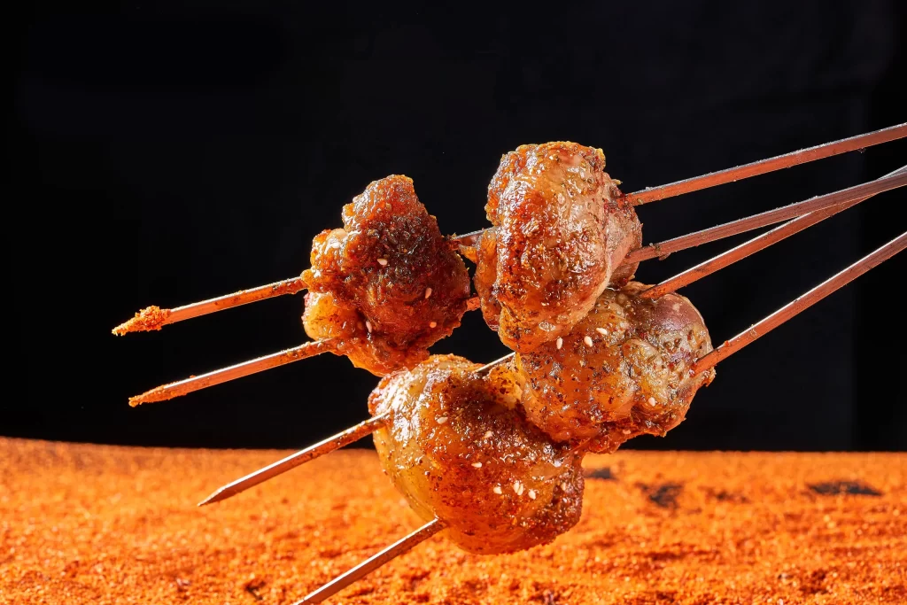 Golden Brown Pork Skewers with Charred Edges and White Sesame