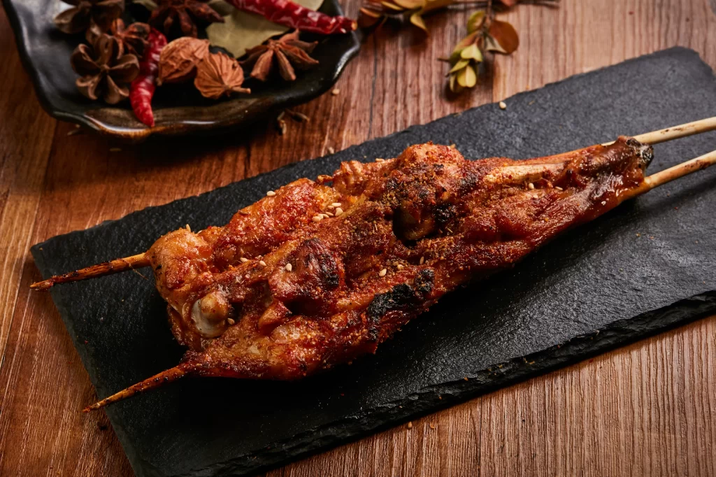 Golden Brown Pork Skewers with Charred Edges on Slate Plate 烤.鸡.翅(3