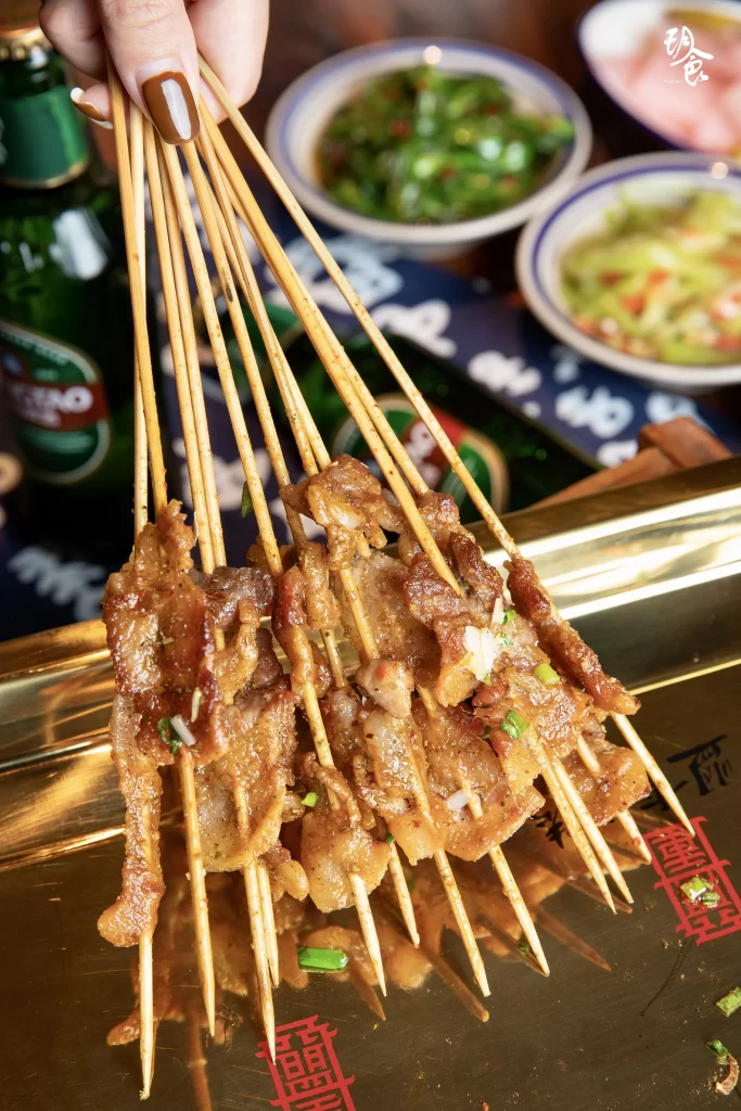 Golden Brown Pork Skewers with Fresh Green Onions on Gold Tray
