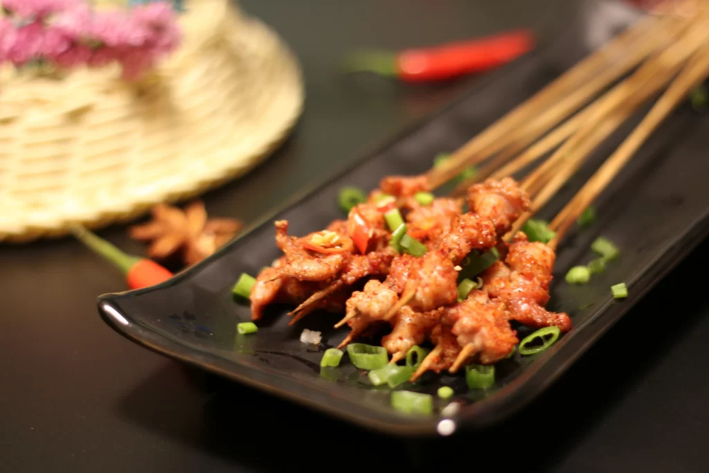 Golden Brown Pork Skewers with Green Onions on Black Plate (31).JP