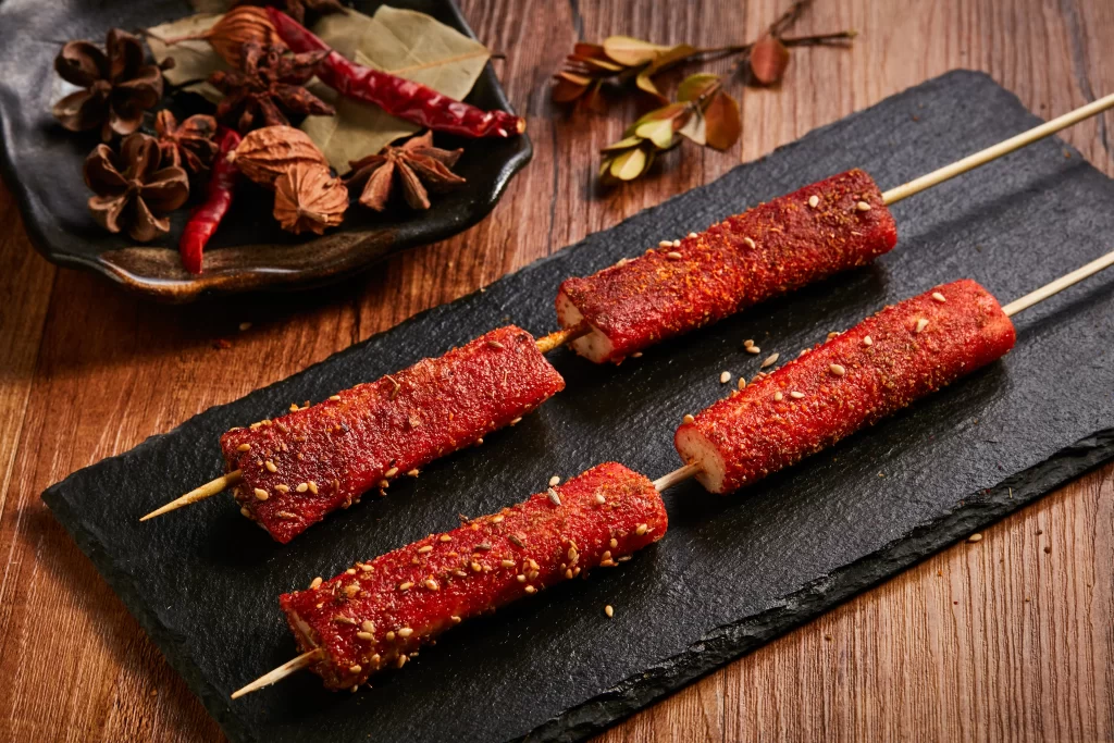 Golden Brown Pork Skewers with Reddish Marinade on Slate Plate