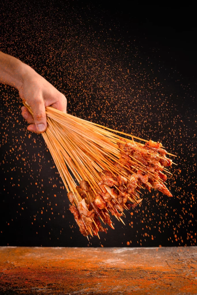 Golden Brown Pork Skewers with Reddish Seasoning in Motion