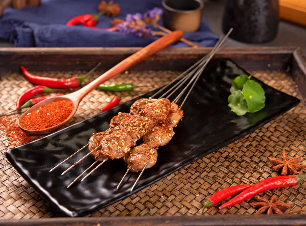 Golden Brown Pork Skewers with Reddish Spices on Black Plate 8-13(3)