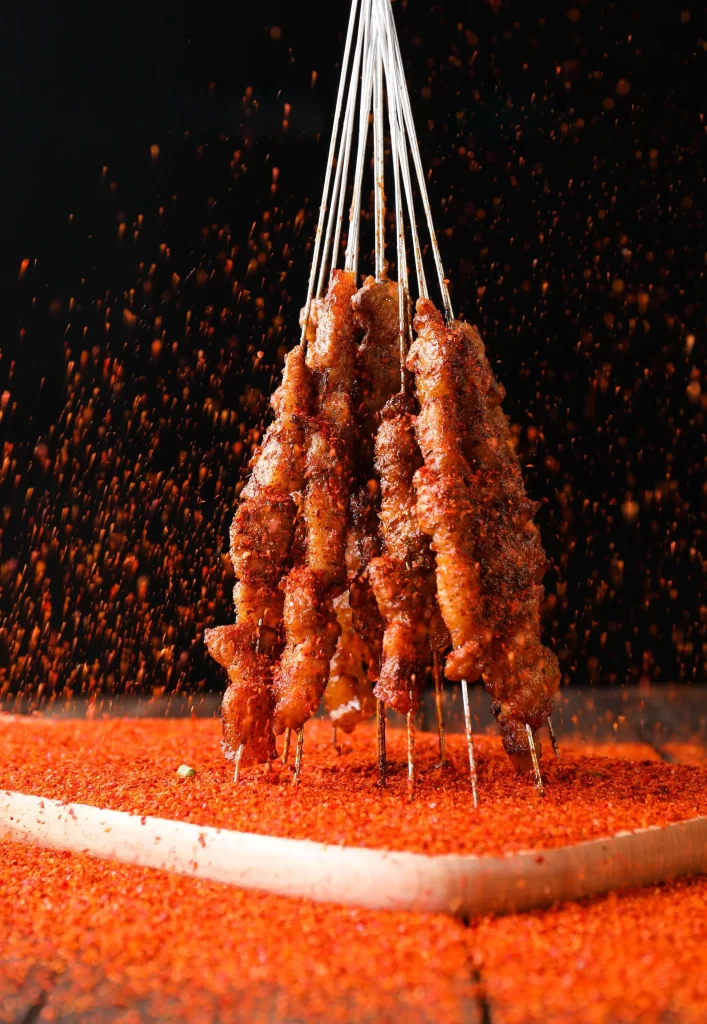 Golden Brown Pork Skewers with Reddish Spices on Wooden Tray
