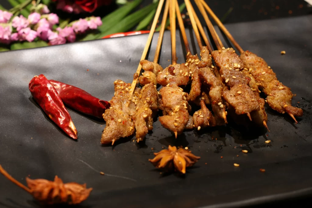 Golden Brown Pork Skewers with Sesame and Chili Garnish