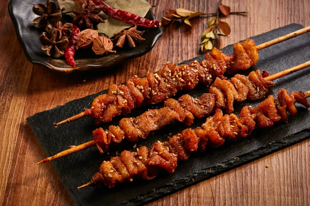 Golden Brown Pork Skewers with Sesame on Slate Plate