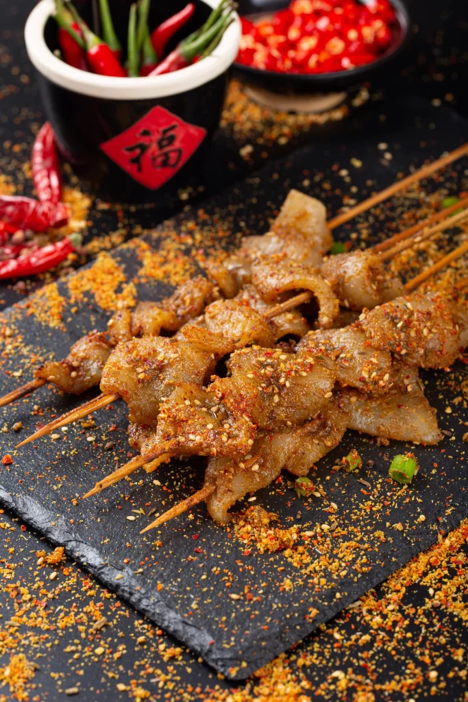 Golden Brown Pork Skewers with Spicy Seasoning on Slate
