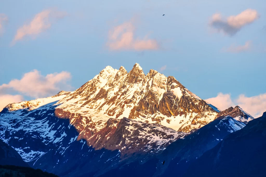 golden hour snow-capped peaks blue sky pink clouds mountain ridges