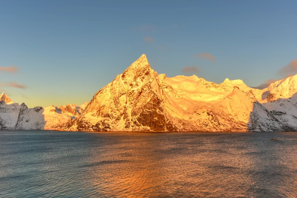 golden hour snow-capped peaks tranquil waters clear sky warm mountainous