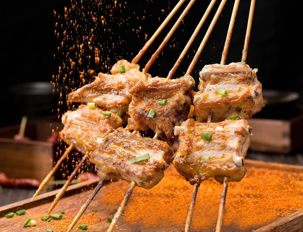 Golden Pork Skewers with Green Onions on Wooden Tray